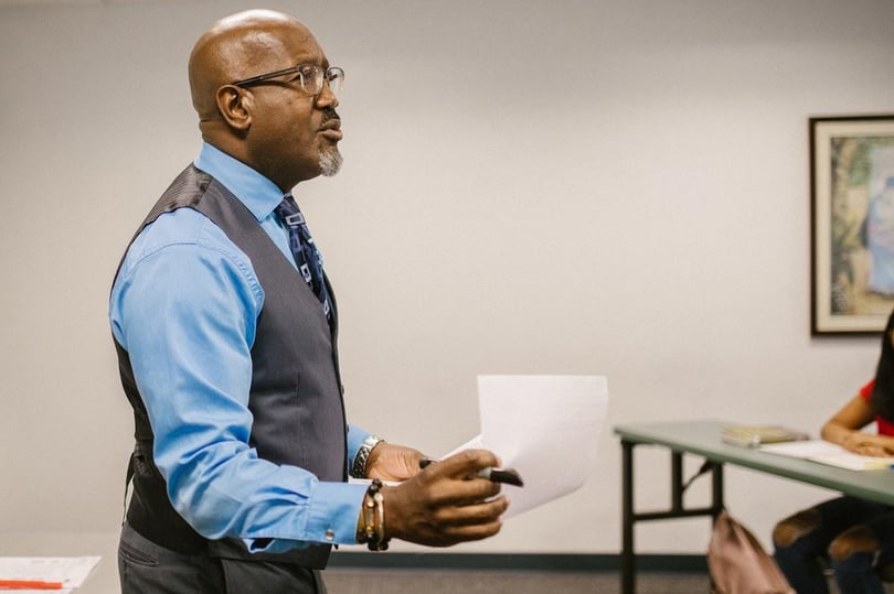 Instructor speaking at the front of a class